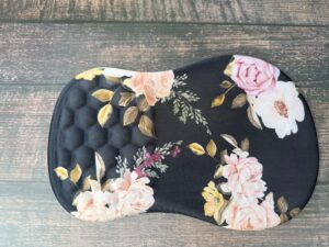 Floral-patterned black seat cushion on wooden floor.